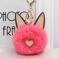 Gros plan d'un charmant pompon oreilles de chat rose avec cœur et fermoir doré - Rouge pastèque