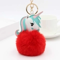 Détail d'un pompon rouge en fausse fourrure et d'un charm licorne coloré avec anneau doré - Rouge