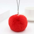 Detail of red faux rabbit fur pom pom charm with silver lobster clasp and black lanyard cord - Red