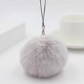 Close-up of soft purple faux fur pompom keychain with silver metal lobster clasp detail - Off-White Grey