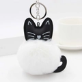 Detailed view of black cat leather charm with fluffy white faux fur pompom and silver ring - White