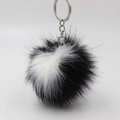Detailweergave van een pluizige zwart-witte faux fur pompon sleutelhanger met metalen ring - Zwart-wit Tint