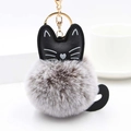 Close-up of fluffy grey and white cat keychain with gold metal ring and leather cat head - Gray And White With Gold Ring