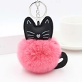Detail shot of a soft pink faux fur pompom cat keychain with black ears and silver ring - Deep Pink