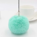 Close-up of fluffy mint green faux fur pom pom keychain with silver metal ring - Light Green