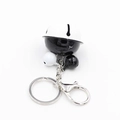 Close-up of star-hollowed black and white bell charm with metal lobster clasp and ring - Black and White