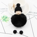 Detail eines schlafenden Baby-Plüschanhängers mit schwarzem Kunstfell und Strickmütze - Schwarz