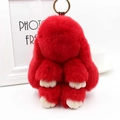 Gros plan du porte-clés lapin en peluche rouge avec anneau doré et pattes blanches - Rouge