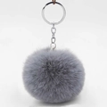 Close-up of a soft grey faux fur pompom keychain with a silver metal ring and chain link - Medium Grey