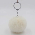 Detail view of the soft ivory faux fur pompom keychain with silver metal ring and chain - Off White