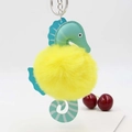 Close-up of yellow and green seahorse plush keychain with detailed leather stitching - Yellow