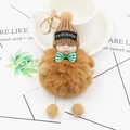 Détail du porte-clés poupée bébé endormi avec boule en peluche et bonnet en tricot - Café