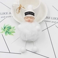 Close-up of a white plush sleeping baby keychain with a knit hat and gold ring - White