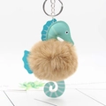 Detail of seahorse keychain with brown faux fur pompom and mint green leather accents - Khaki