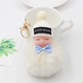 Détail d'un porte-clés poupée endormie avec pompon en peluche beige et attache dorée - Blanc Cassé (Avec Nœud)