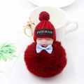 Gros plan sur un porte-clés poupée bébé endormi avec un grand pompon en fourrure bordeaux - Rouge Vin (Avec Nœud)