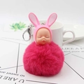 Close-up of fluffy pink bunny ear sleeping baby keychain with a soft faux fur pompom ball - Rose Red