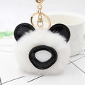 Detailed macro shot of the plush panda keychain with soft white fur and gold metal clasp - White