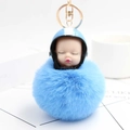 Detailed macro view of the fluffy blue pompom with a cute baby face in a helmet - Blue