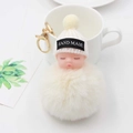Gros plan du porte-clés bébé endormi en peluche fait main avec pompon et anneau doré - Blanc Cassé