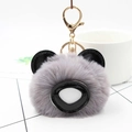 Détail d'un porte-clés panda en peluche grise avec yeux en cuir verni et fermoir doré - Gris clair