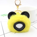 Détail d'un porte-clés panda jaune en fausse fourrure avec boucle dorée et oreilles noires - Jaune