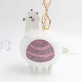 Close-up of fluffy white alpaca plush keychain with pink glitter saddle and gold clip - White