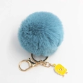 Dettaglio portachiavi a pompon blu con chiusura dorata e ciondolo a forma di papera gialla - Diametro Pon Pon 8cm / Blu lago