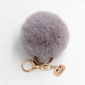 Vue détaillée du porte-clés pompon gris avec breloque citrouille et fermoir doré - Diamètre Pompon 8cm / Gris clair