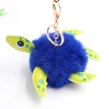 Close-up of fluffy blue turtle plush keychain with green polka dot limbs and golden clasp - Pom Pom Diameter 8cm / Sapphire Blue