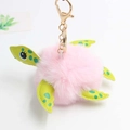 Detail of pink plush turtle keychain featuring green leather accents and gold metal clip - Pom Pom Diameter 8cm / Light Pink