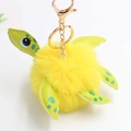 Detail of yellow plush turtle keychain with green dotted limbs and golden metal clasp - Pom Pom Diameter 8cm / Yellow