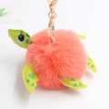 Detail showing pink plush turtle keychain with green patterned faux leather flippers - Pom Pom Diameter 8cm / Orange