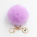 Close-up of fluffy purple faux fur pompom keychain with golden lobster clasp and pearl charm - Pom Pom Diameter 8cm / Violet