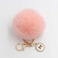 Close-up of pink faux fur ball keychain with golden metal ring and bow pearl pendant - Pom Pom Diameter 8cm / Pink