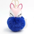 Close-up of sleeping fox keychain with dark blue plush fur ball and golden metal ring - Sapphire Blue