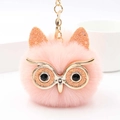 Gros plan du porte-clés hibou rose avec des yeux pailletés et une fourrure synthétique - Rose