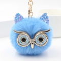 Detalle de llavero de búho de peluche azul con orejas de lentejuelas y ojos metálicos dorados - Azul