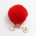 Detail eines roten Kunstfell-Pompons mit goldenem Verschluss und Perlenanhänger - Pompon Durchmesser 8cm / Rot