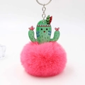 Detail view showing a vibrant magenta faux fur pom pom and acrylic cactus keychain charm - Watermelon red