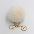 Detailed view of fluffy cream faux fur pompom keychain with pearl bow pendant - Pom Pom Diameter 8cm / Off White