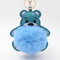 Detail eines blaugrünen Bären-Schlüsselanhängers mit weichem Pompon und Goldkarabiner - Pompon Durchmesser 8cm / Blau