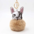 Detail eines süßen Bulldogge-Plüschanhängers mit braunem Pelzball und Goldring - Khaki