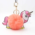 Close-up of fluffy coral pink pompom keychain with cute unicorn leather charm - Orange Red