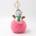 Detail eines rosa Bommel-Schneemann-Schlüsselanhängers mit Goldring auf weißem Hintergrund - Dunkelrosa