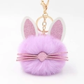 Macro view of purple faux fur bunny keychain with glittery pink ears and gold metal clip - Violet