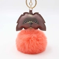 Close-up of fluffy orange pom-pom puppy keychain with brown leather details and gold ring - Pom Pom Diameter 8cm / Orange Red