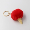 Close-up of red fluffy ball ice cream keychain with beige resin cone and golden ring - Red