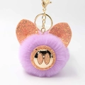 Vue détaillée du porte-clés pompon violet avec oreilles de cochon brillantes et fermoir doré - Mauve Clair