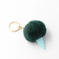 Close-up of green plush pompom ice cream keychain with blue cone and gold ring - Turquoise Green